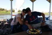 Ehepaar deutsche Touristen auf Motorboot in Luxor und auf dem Tisch frische Früchte